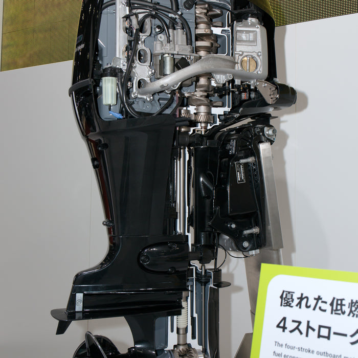 Suzuki outboard motor on display, rear view showing engine cowling and lower unit