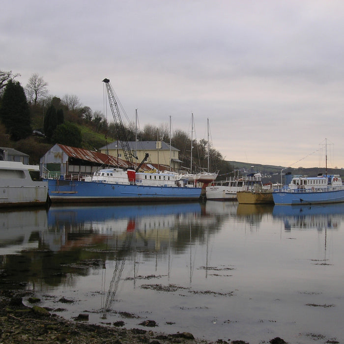 Boats moored at a quiet boatyard in the off-season under overcast winter skies